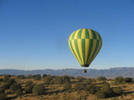 Green and yellow hot air balloon lifting off.